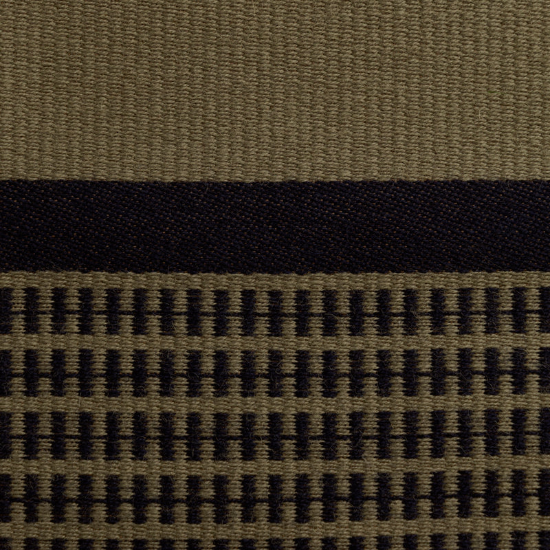 Close-up of the olive Danish woven wool fabric from Kjellerup Væveri, featuring a distinctive checkered pattern. The fabric showcases a blend of dark olive and blue tones, reflecting the exquisite craftsmanship and refined texture characteristic of Kjellerup Væveri's designs, used in the Kelly Rutherford x August Sandgren Limited Edition Collection.